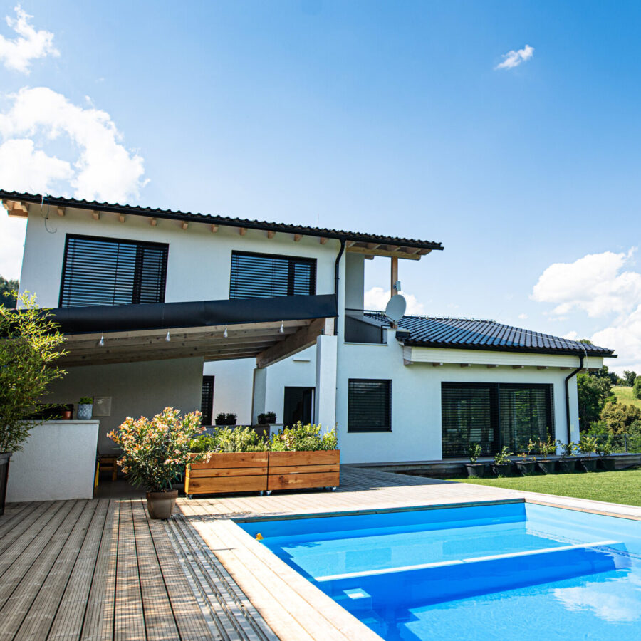 House with swimming pool outdoors in backyard garden in the countryside.
